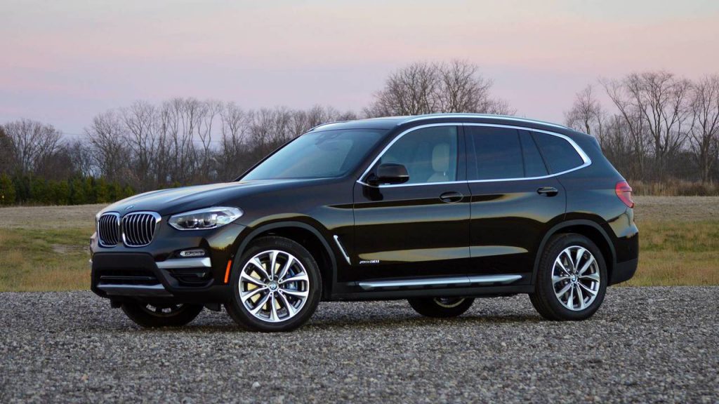 Black BMW X3 on the road after a windscreen and side window replacement.