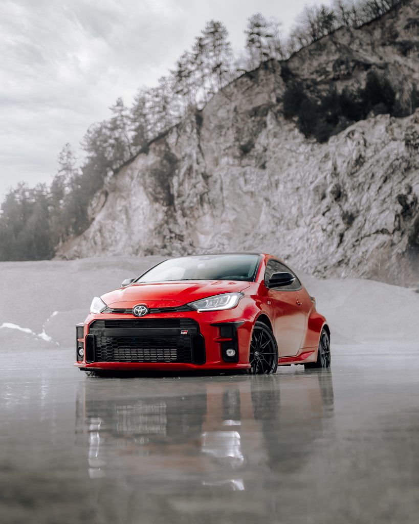 Outdoors Red Toyota Yaris with new car glass repairs
