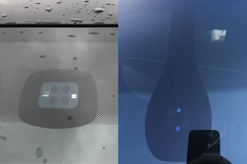 Close-up of a rain sensor mounted to the inside of a windscreen behind the rearview mirror