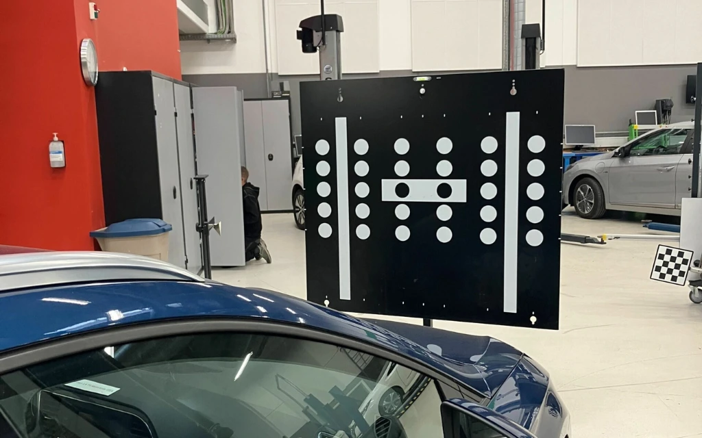 Windscreen camera calibration in progress on a vehicle in a workshop